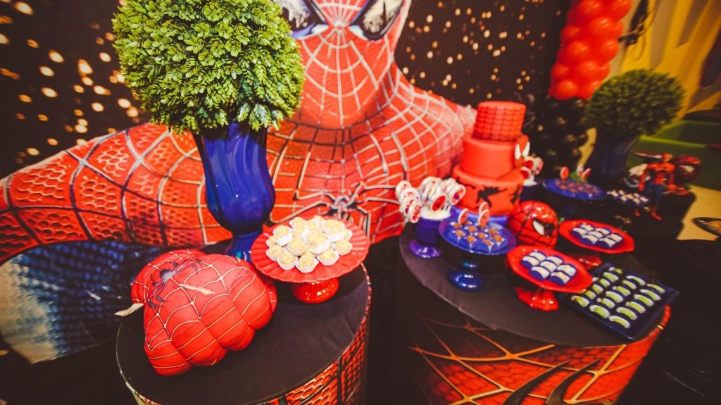 Vibrant Spider-Man themed decorations with cake and desserts for a festive birthday party.