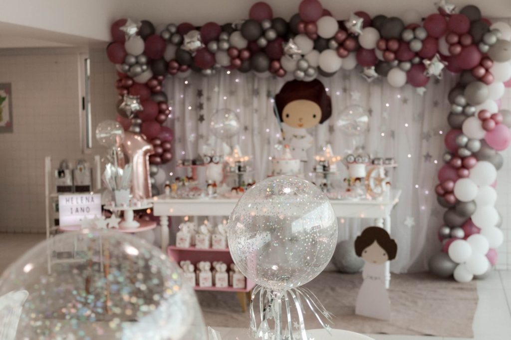 A magical indoor birthday party setup featuring balloons, fairy lights, and themed decorations.